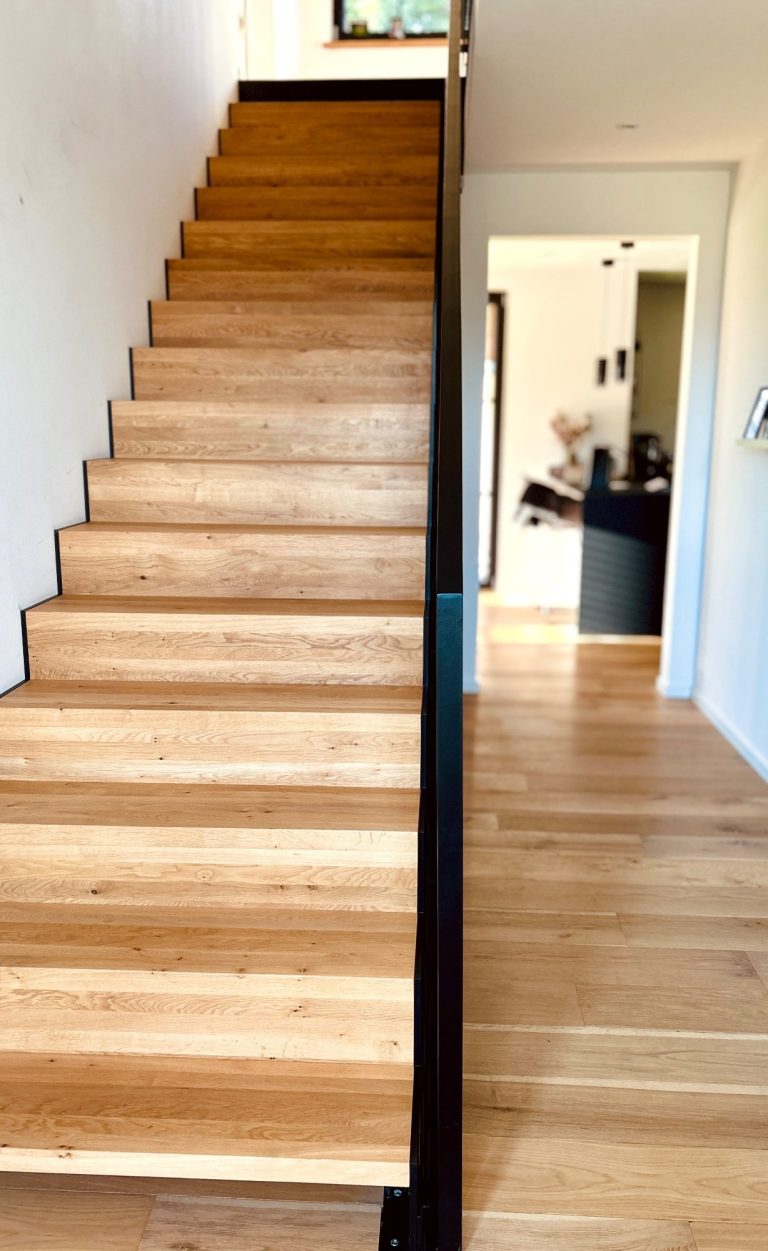 Holztreppe Innenbereich Moderne Innentreppe aus Holz mit schwarzem Geländer im Wohnhaus