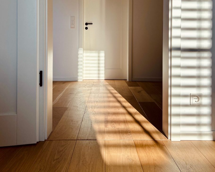 Flur mit Holzboden und Innentür Heller Flur mit Holzboden, weißer Innentür und Lichteinfall durch Fenster